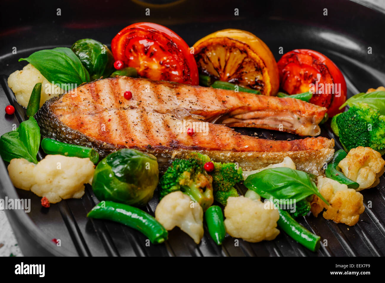 Salmone alla griglia con le verdure su una padella per grigliare Foto Stock