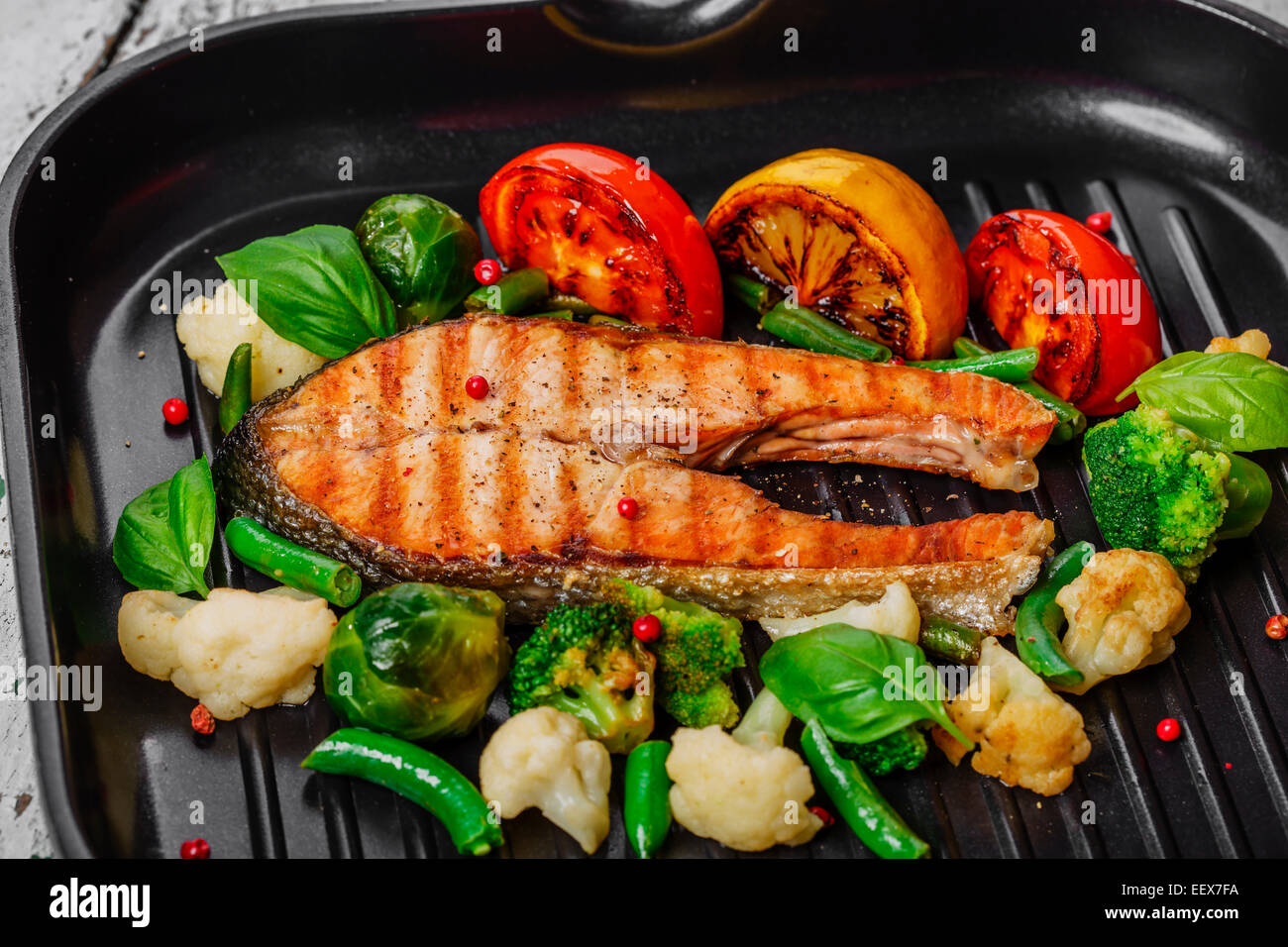 Salmone alla griglia con le verdure su una padella per grigliare Foto Stock