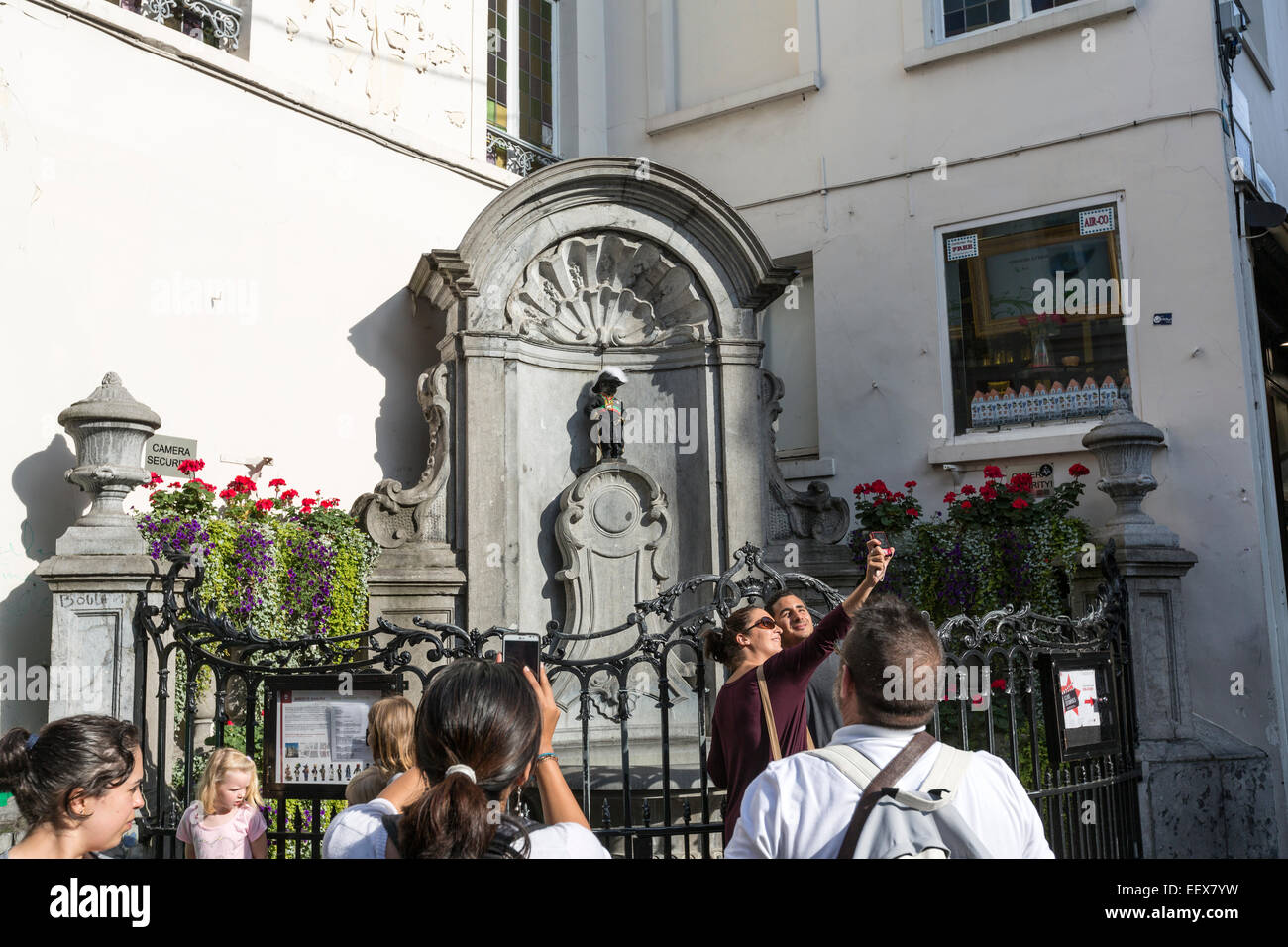 I turisti tenendo selfie con il Manneken Pis, top attrazione di Bruxelles Foto Stock