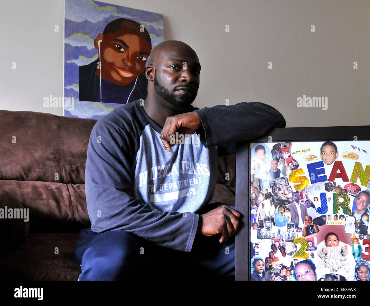 Sean Reeves Suor ha perso il suo figlio Sean Jr. nel 2011 per una ripresa in New Haven. Egli riflette sul padre del giorno dal suo figlio la morte. Egli è mostrato nella sua East Haven home con un collage, destra e un dipinto del Figlio suo fatto da un membro della famiglia, dietro di lui. Giugno 10, 2014. Foto Stock