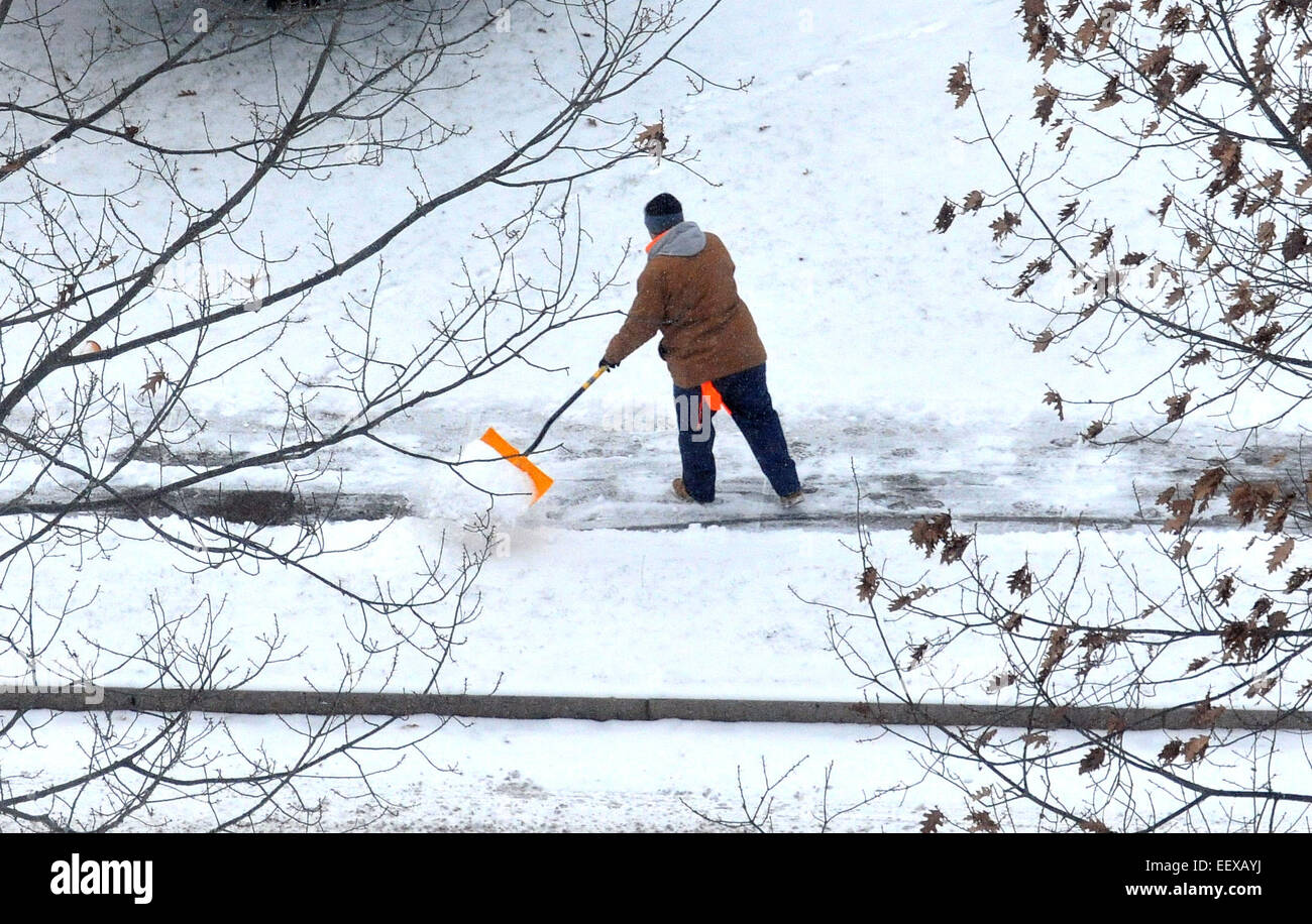 Un uomo di badili neve lungo Eastern Street a New Haven nel corso del sabato della tempesta di neve. Foto Stock