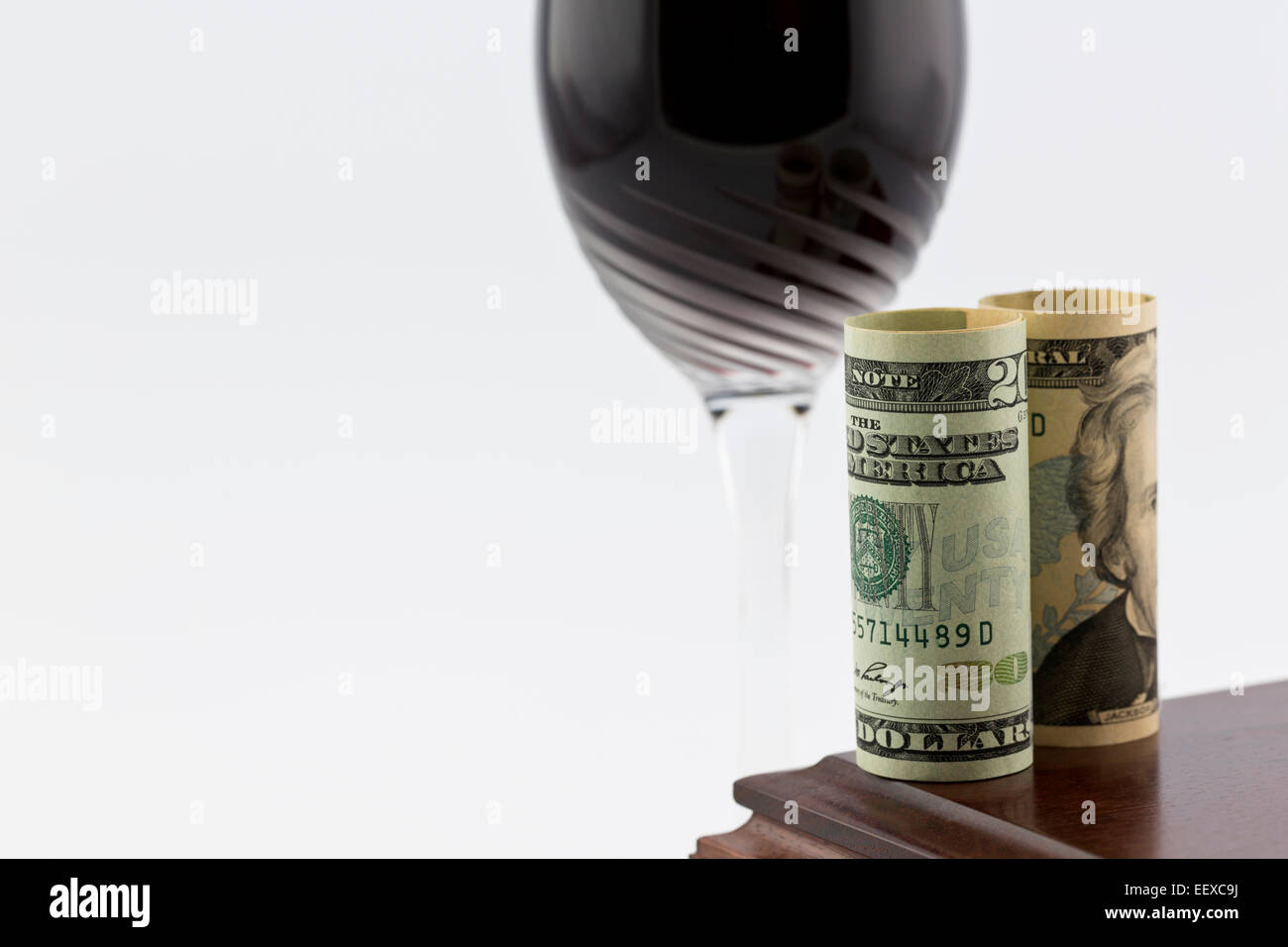 Moneta americana immessi sul legno lucidato casella nella parte anteriore dello stelo di vetro con il vino rosso; l'immagine orizzontale con copia in bianco lo spazio. Foto Stock