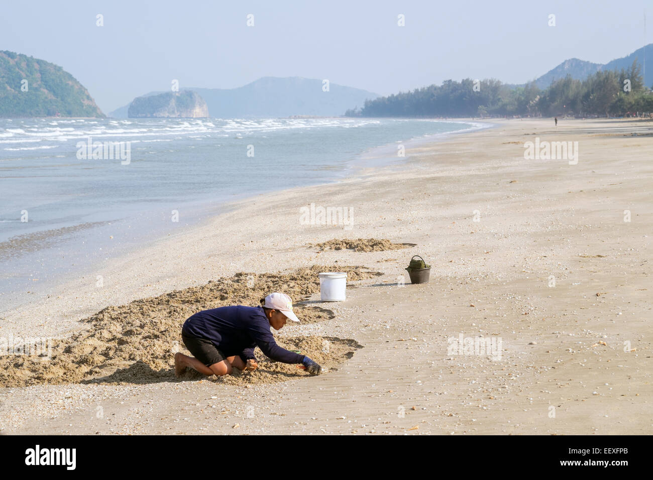 La vita è una spiaggia - Thai donna cozze di prelievo presso la spiaggia di Baia dei Delfini, Prachuap Khiri Khan, Thailandia. Foto Stock