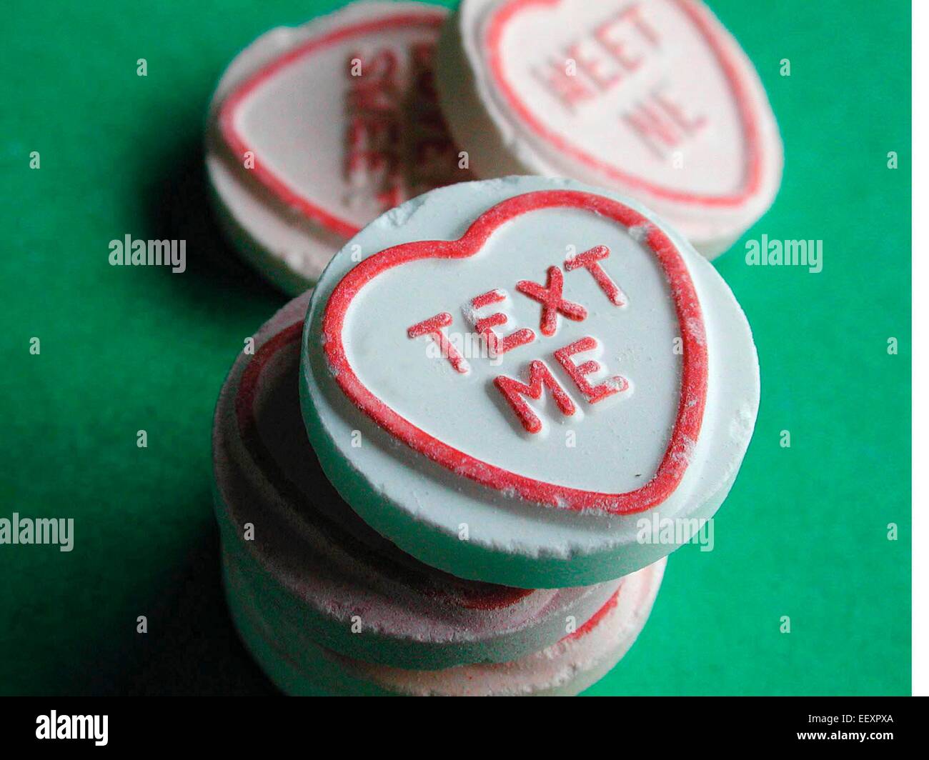 Text me Written on Love Hearts dolciumi prodotti da Swizzels Matlow Limited, con le iconiche caramelle pastello a forma di cuore con messaggi romantici, un popolare marchio di dolci britannico ampiamente associato ai regali, San Valentino e nostalgica cultura dolciaria, Regno Unito. Foto Stock