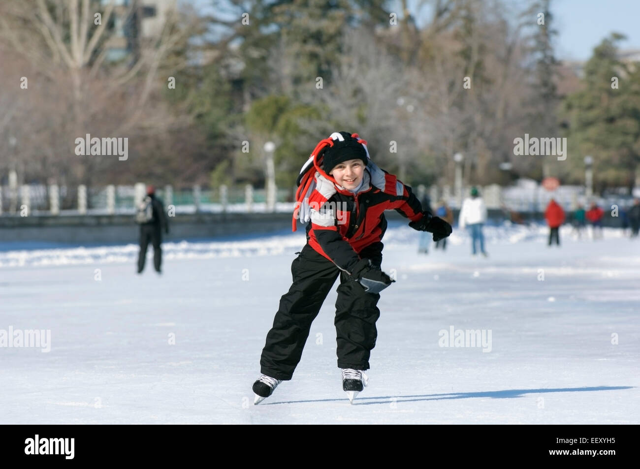 Ragazzo giovane pattinaggio sul ghiaccio all'aperto in inverno Foto Stock