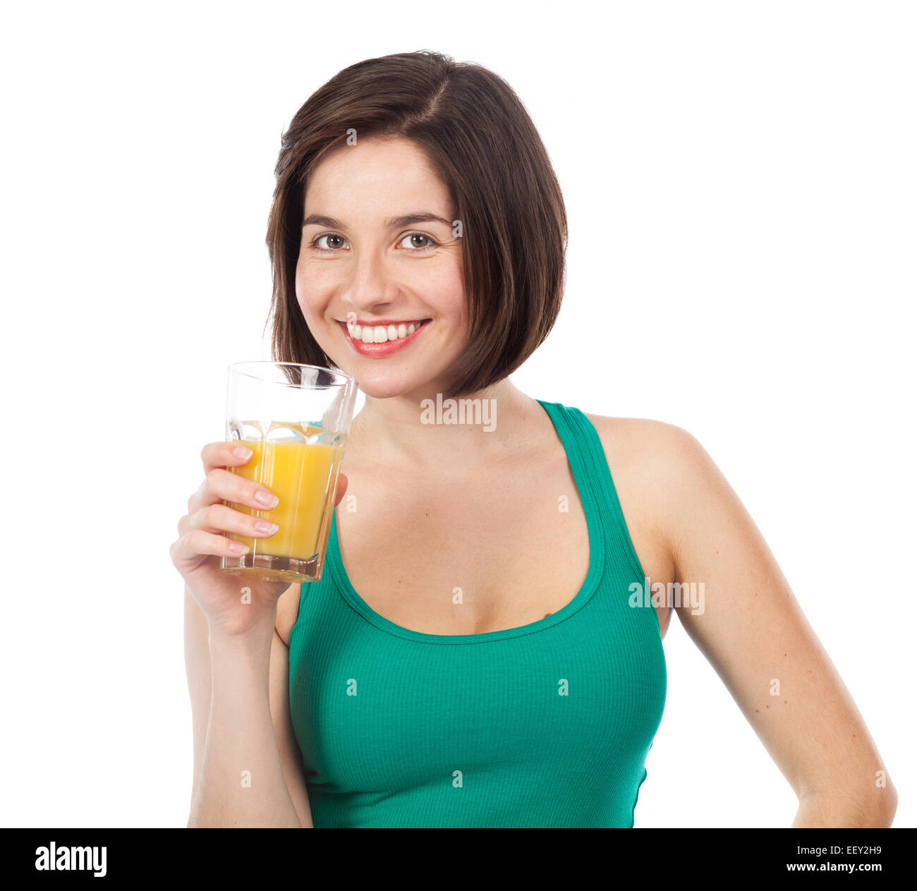 Ritratto di una giovane bruna bere un succo di arancio, isolato su bianco Foto Stock