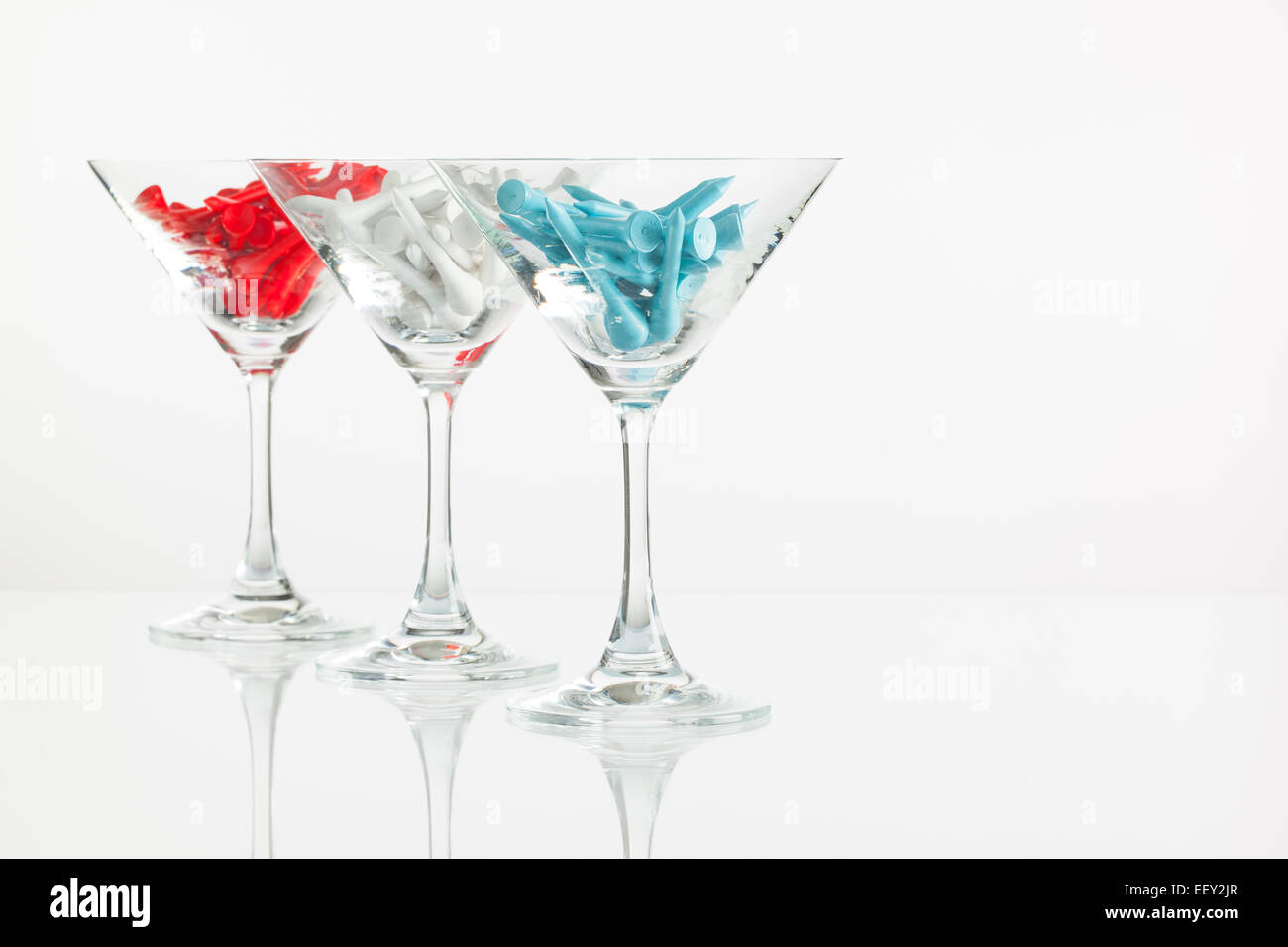 Tre bicchieri di champagne e attrezzature da golf sul tavolo di vetro Foto Stock