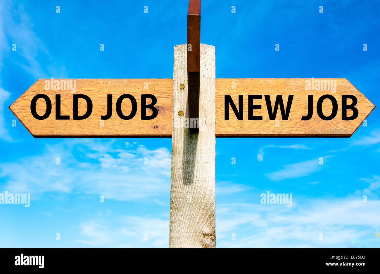 Indicazioni del cartello in legno con due frecce opposte oltre il cielo blu chiaro, lavoro di vecchio e nuovo lavoro, cambiamento di carriera immagine concettuale Foto Stock