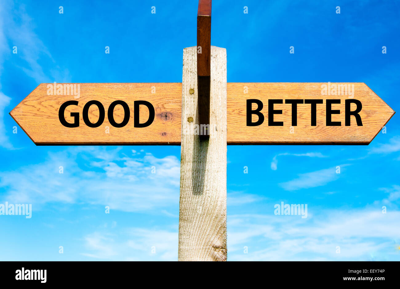 Indicazioni del cartello in legno con due frecce opposte oltre il cielo blu chiaro, buona rispetto al meglio messaggi, cambiamento dello stile di vita immagine concettuale Foto Stock