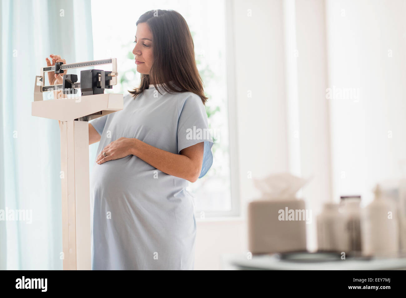 Donna incinta su scala nell'ufficio del medico Foto Stock