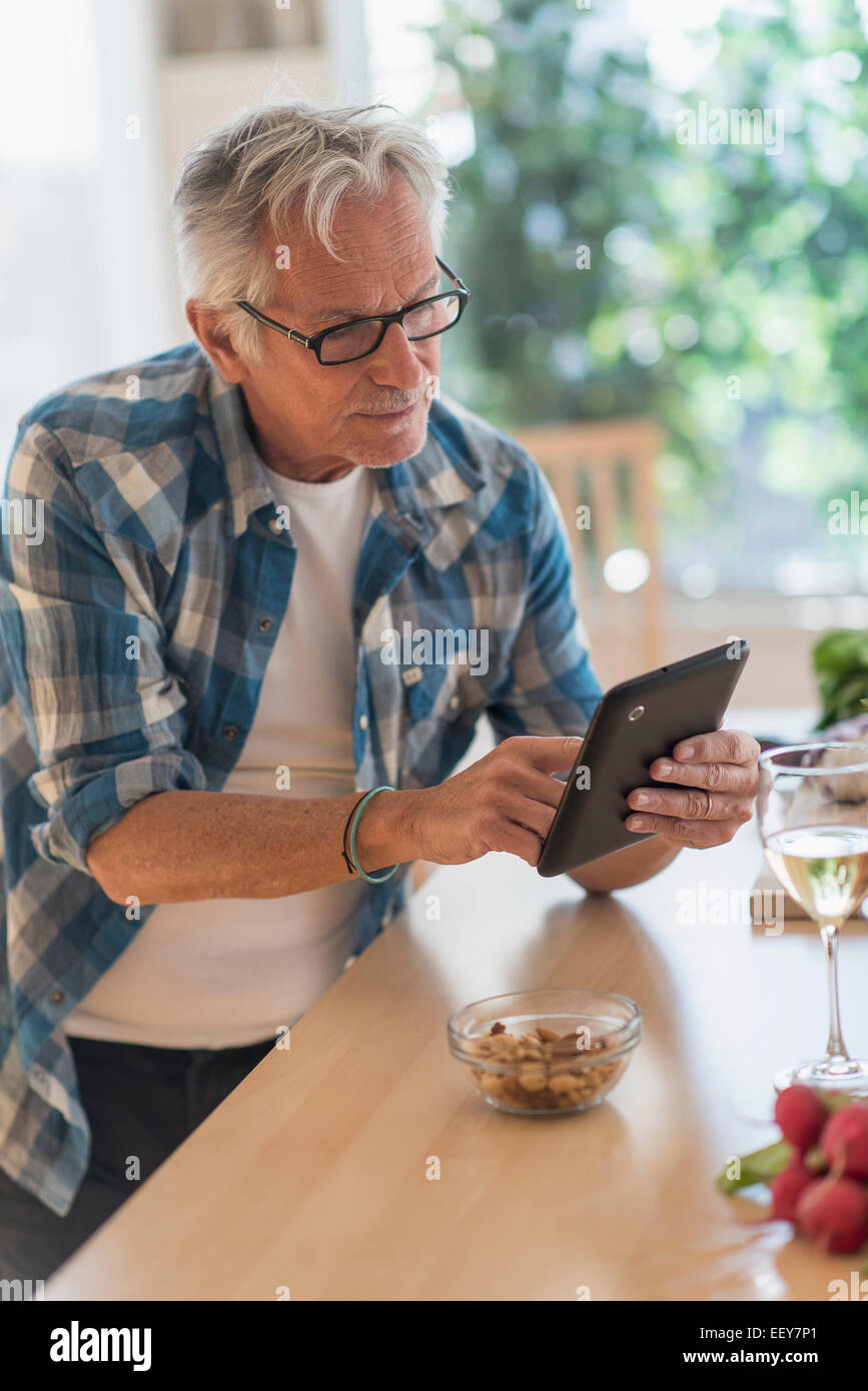 Uomo in cucina utilizzando tablet Foto Stock