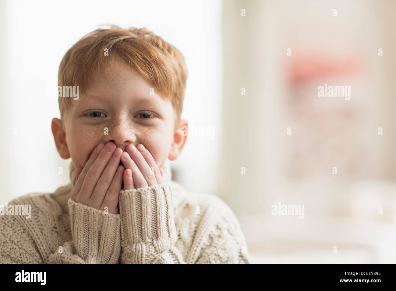 Ritratto di ragazzo (6-7) con le mani per bocca di copertura Foto Stock