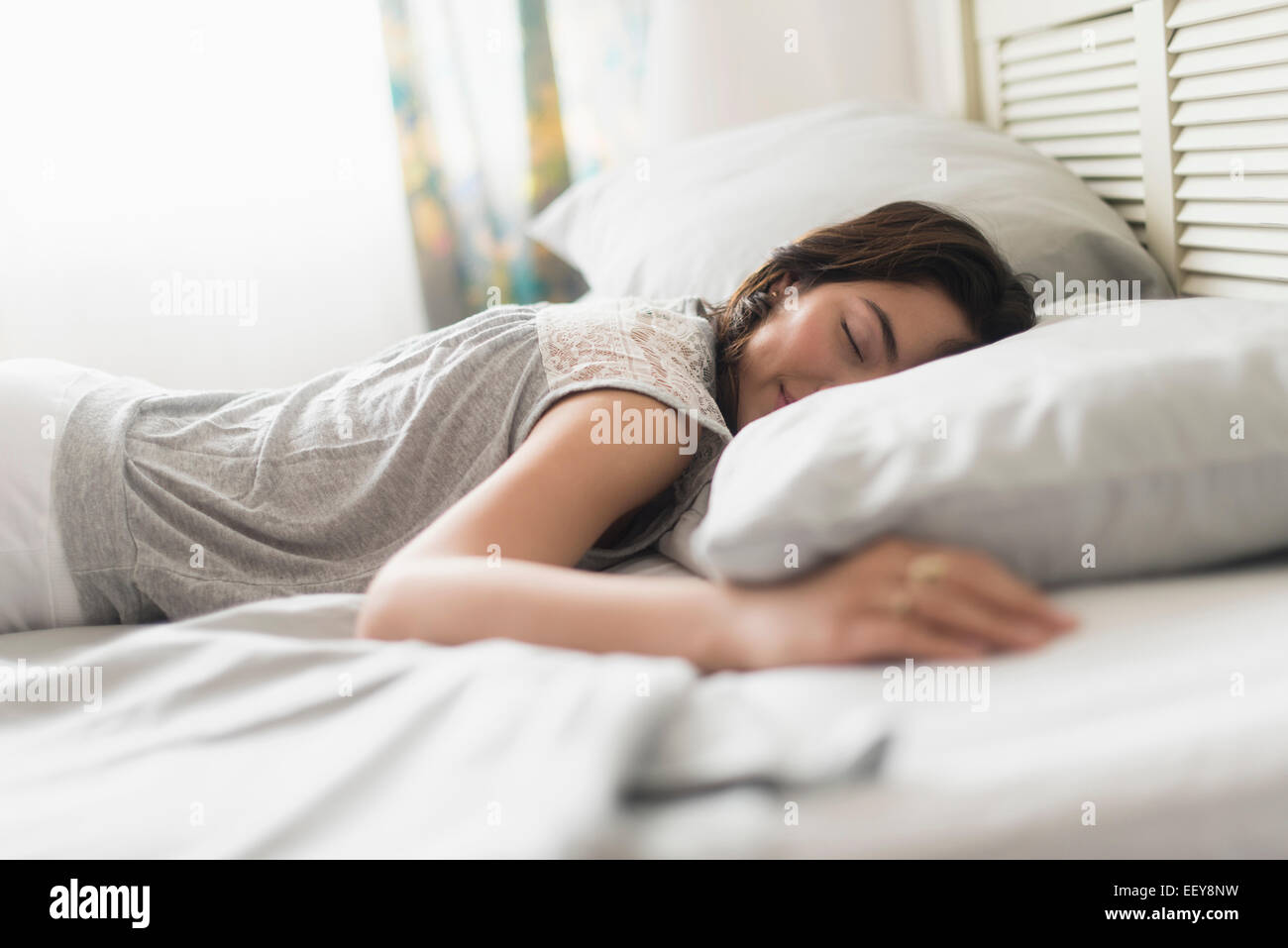 Giovane donna che dorme nel letto Foto Stock