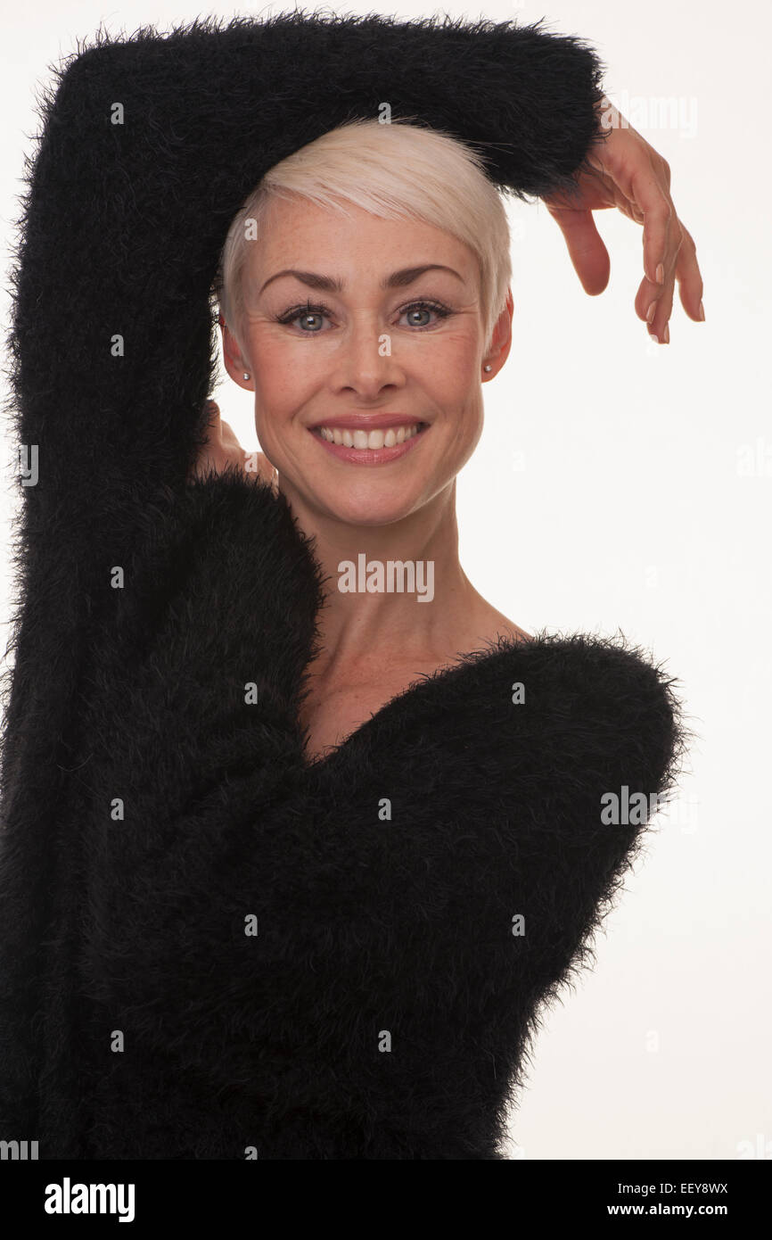 Donna matura sorridente braccia in appoggio sulla sua testa Foto Stock