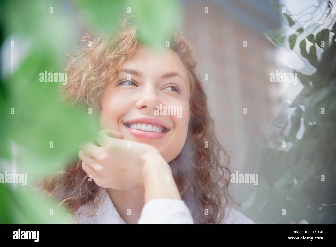 Sorridente giovane donna fantasticando Foto Stock