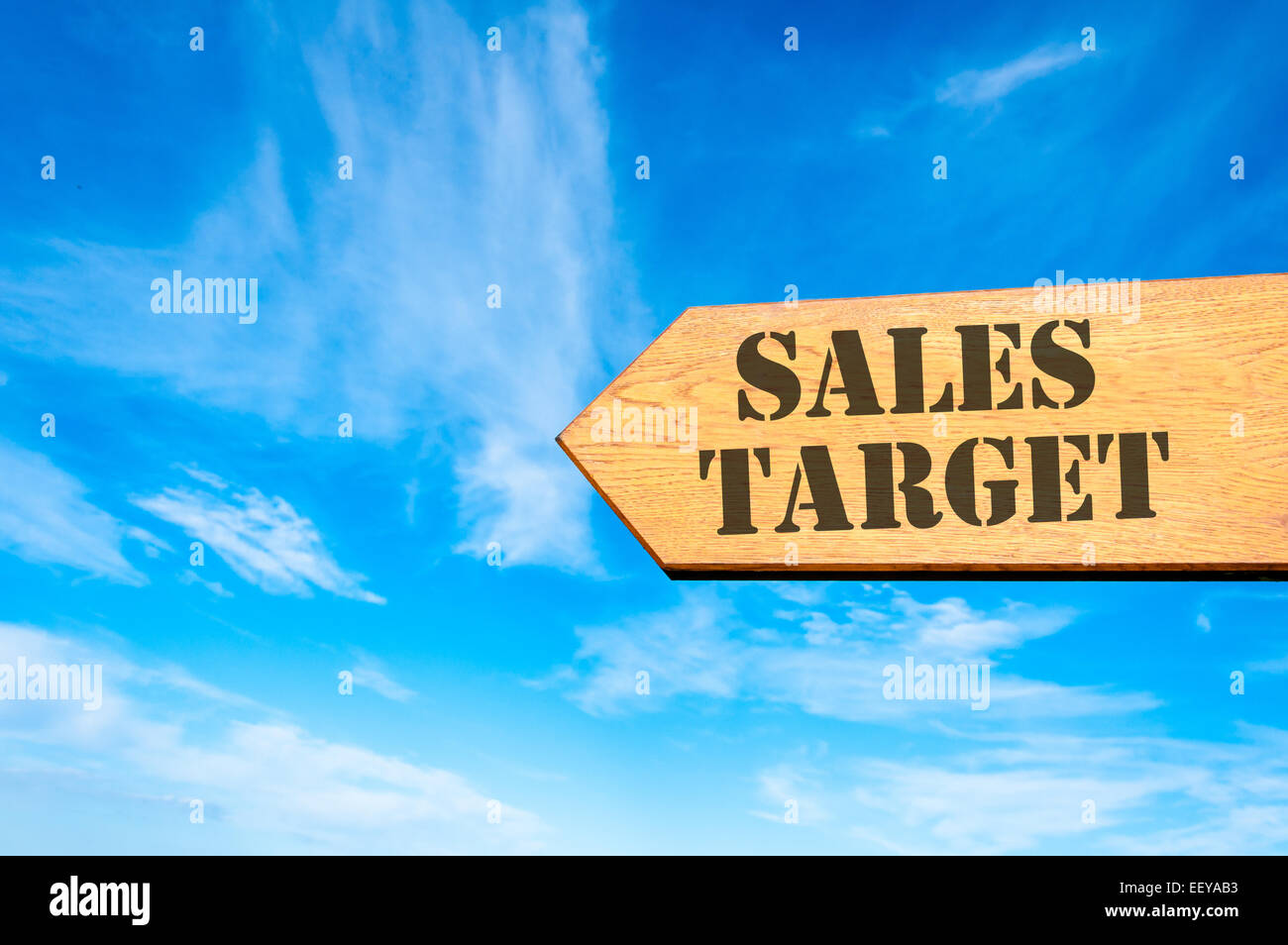 Legno segno di freccia contro il cielo blu chiaro con target di vendita, la redditività del business concept Foto Stock