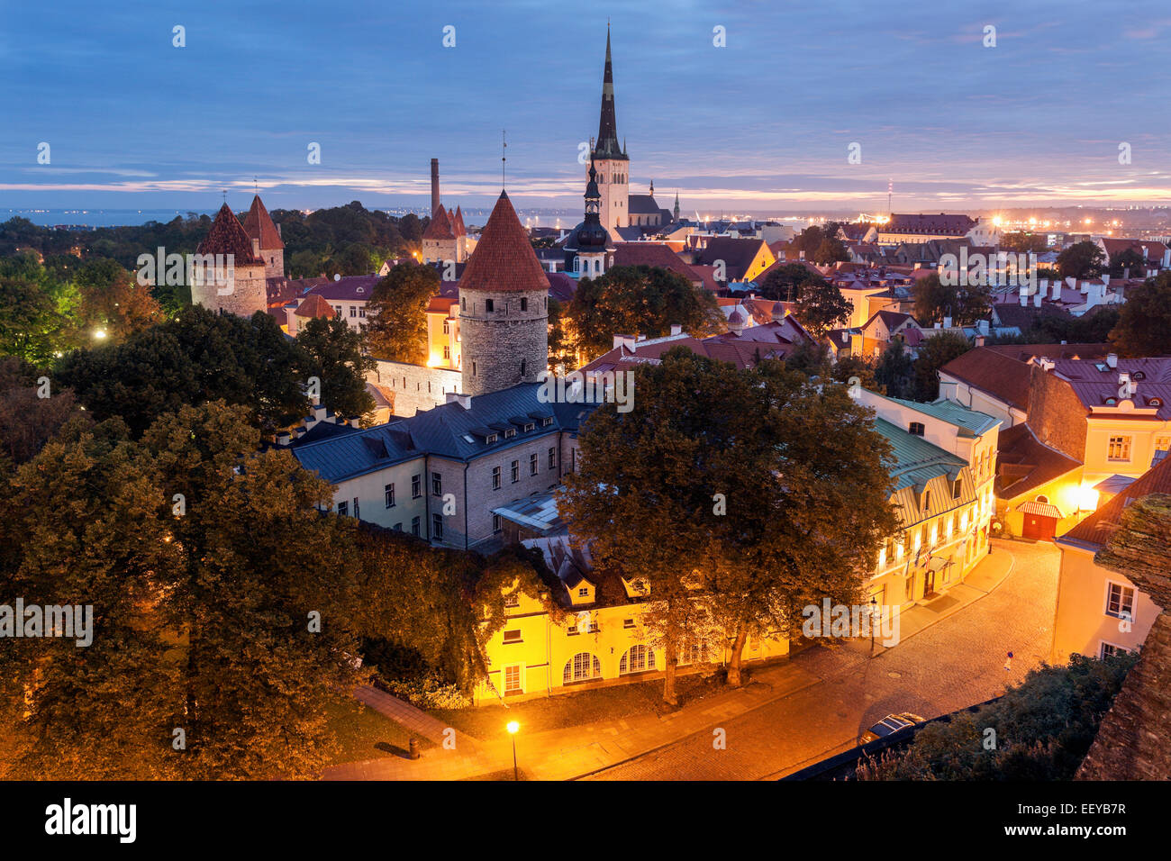 Estonia, Tallinn, San dell'Olaf e della Chiesa che circondano città al crepuscolo Foto Stock