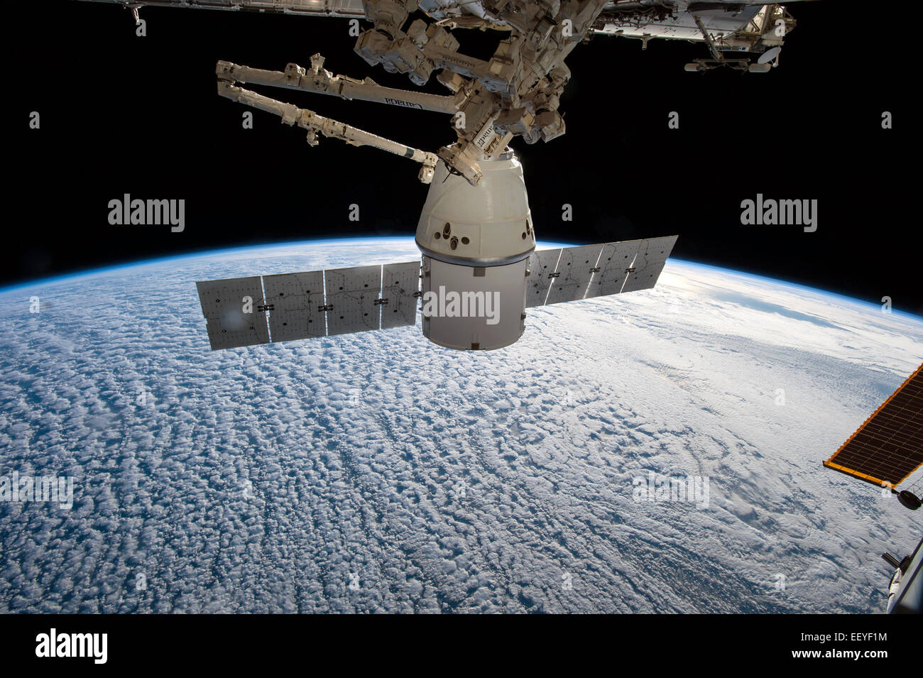 La Stazione Spaziale Internazionale il Canadarm 2 tira il SpaceX Dragon commerciale cargo craft in posizione di aggancio 12 gennaio 2015 in orbita intorno alla terra. Foto Stock