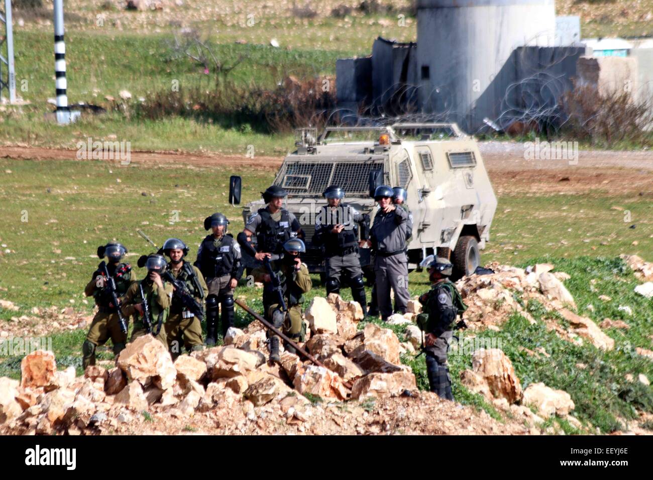 Soldati israeliani stand all'ingresso della Cisgiordania villaggio palestinese di Nabi Saleh. I soldati chiusa la strada che conduce al borgo a causa di un settimanale dimostrazioni di palestinesi che tentano di accedere alle loro terre che sono state adottate da Israele. Settimanale del venerdì dimostrazioni contro l'occupazione militare israeliana e illegale di insediamenti israeliani in Cisgiordania, Palestina furono arrestati e dispersi dai soldati israeliani in diverse città. In Nabi Saleh, un piccolo villaggio palestinese, situato a nord-ovest di Ramallah, abitanti del villaggio e attivisti internazionali si sono riuniti a marzo da Foto Stock