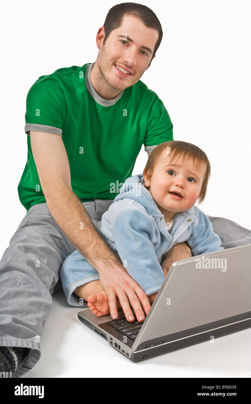 Il padre e il bambino a giocare con il computer portatile Foto Stock