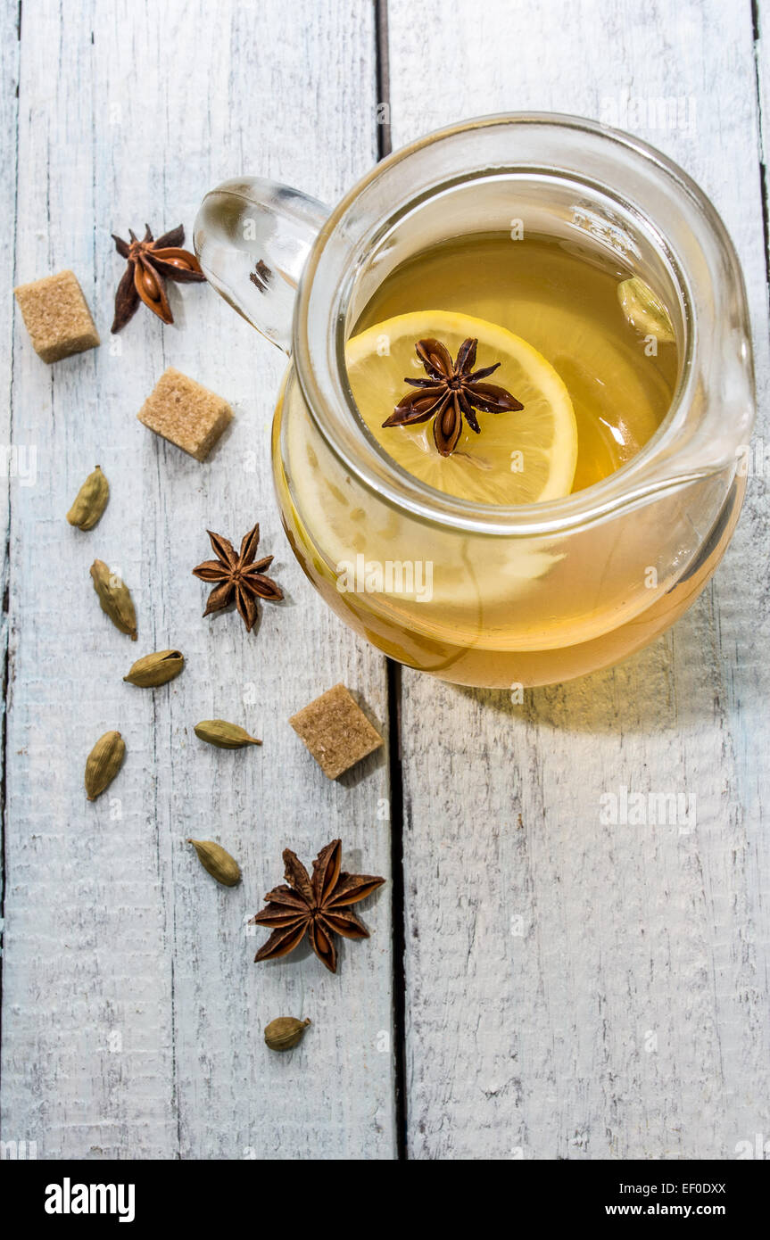 Tè al limone con il cardamomo e anice stellato su una tavola di legno Foto Stock