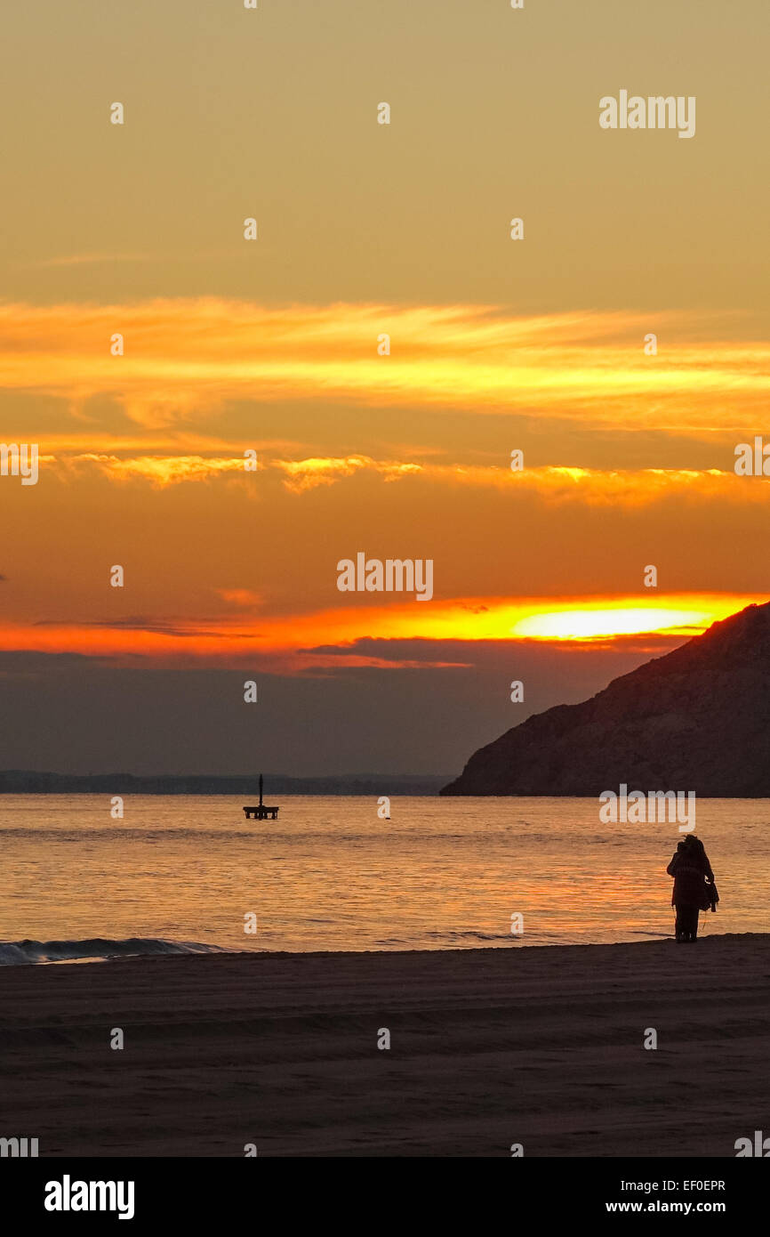Benidorm tramonto arancione con il mare, la sabbia, silhouette e nuvole Foto Stock