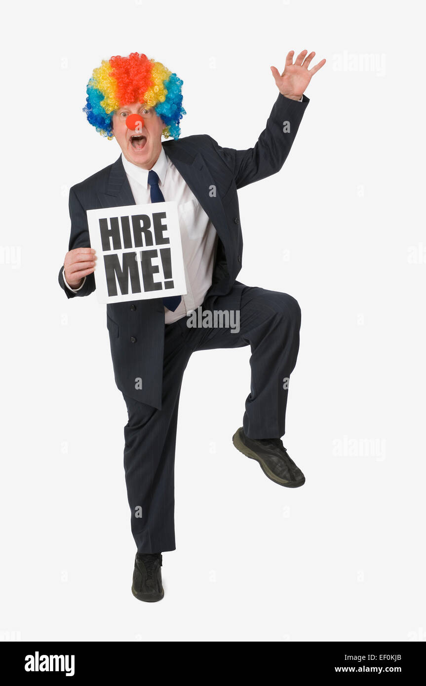 Imprenditore indossando clown naso e parrucca Foto Stock