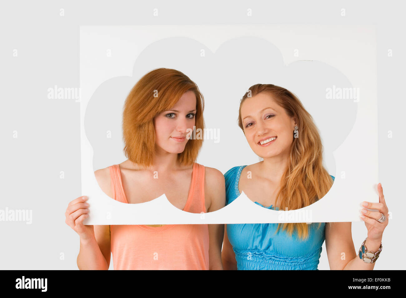Due donne in piedi dietro il cloud tagliare Foto Stock