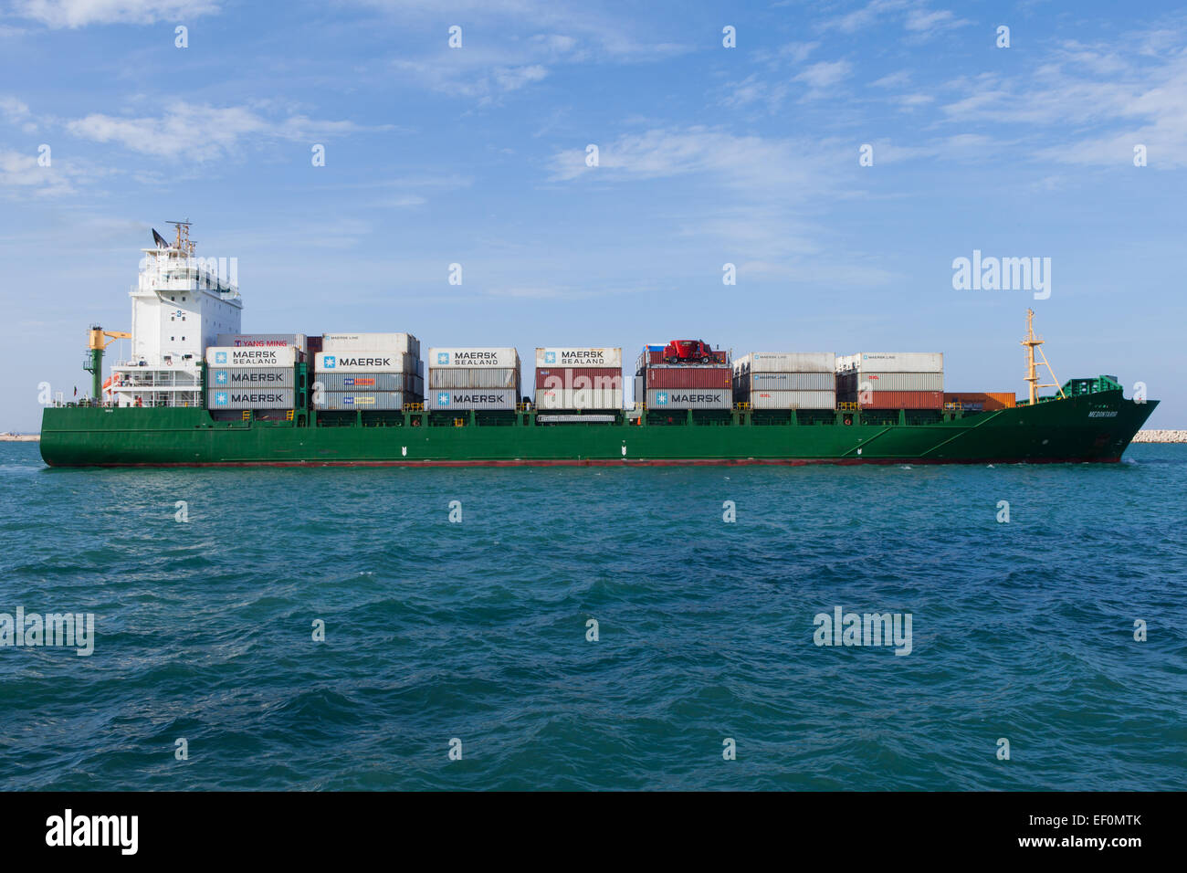 Di medie dimensioni contenitore nave che lascia il porto Foto Stock