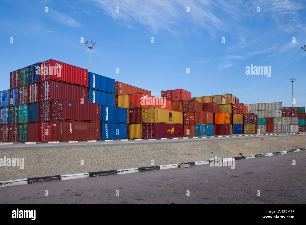 Varie marche e colori di spedizioni di contenitori impilati Foto Stock