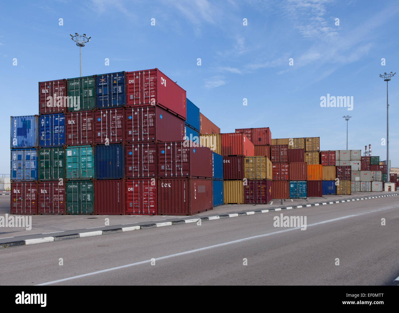 Varie marche e colori di spedizioni di contenitori impilati Foto Stock