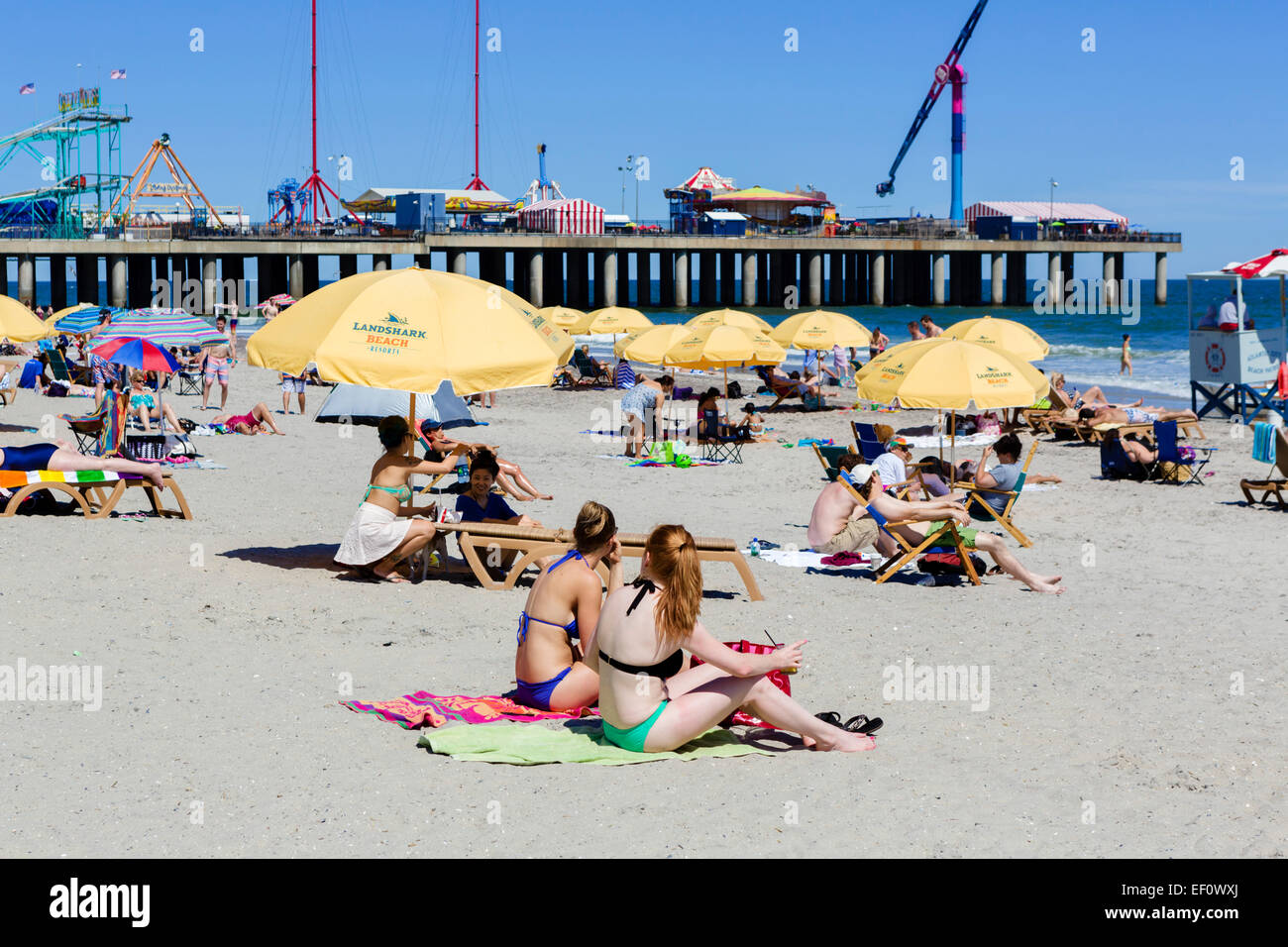 Giovani donne sulla spiaggia di fronte al molo di acciaio, Atlantic City, New Jersey, STATI UNITI D'AMERICA Foto Stock