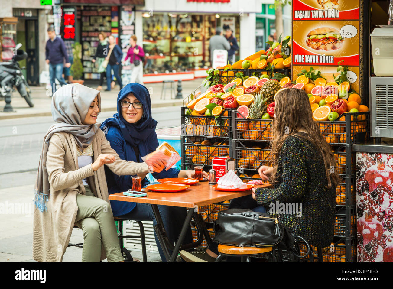 Tre giovani ragazze a mangiare un Felafal e humus all'aperto un ristorante fast food in Sultanahmet, Istanbul, Turchia, Eurasia. Foto Stock