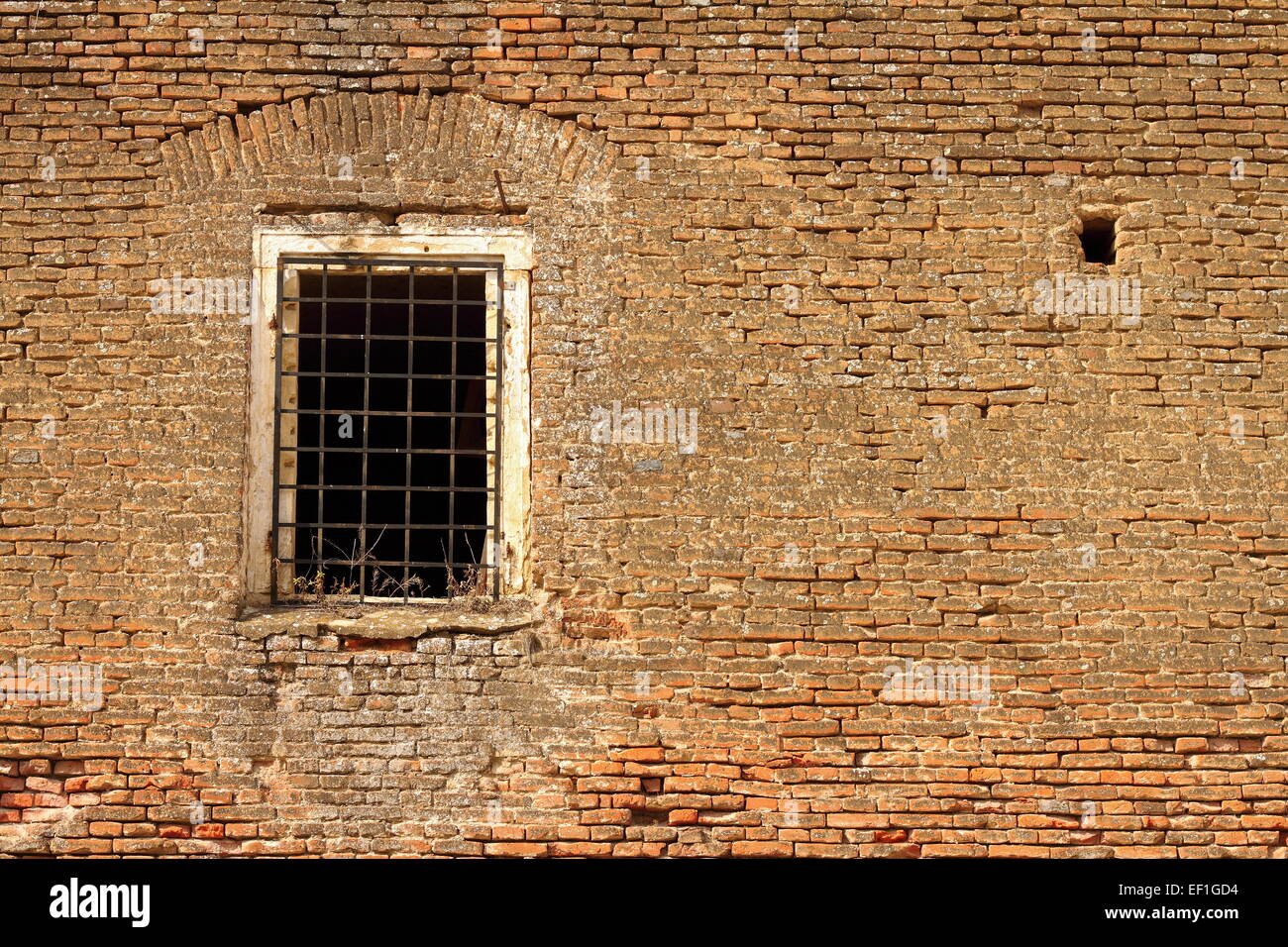 Finestra sul vecchio castello abbandonato a parete, red weathered facciata di mattoni Foto Stock