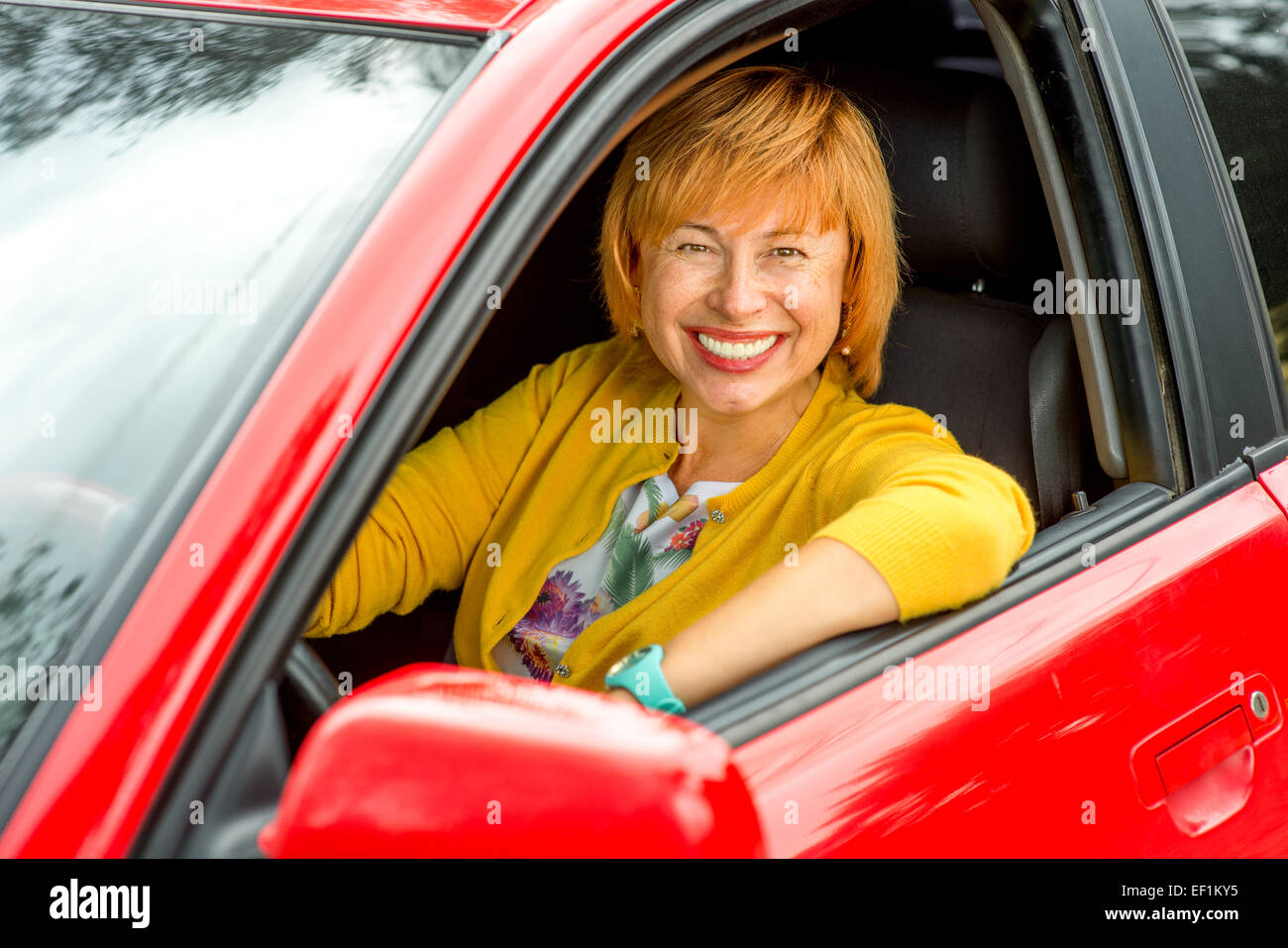 Certi vecchi woman in red car guida Foto Stock