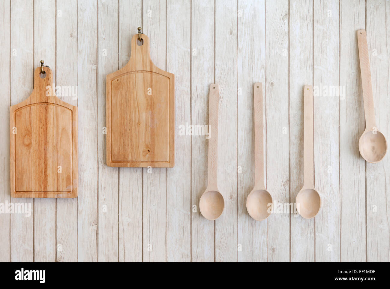 I taglieri e cucchiai di legno appeso alla parete, utensili da cucina Foto Stock