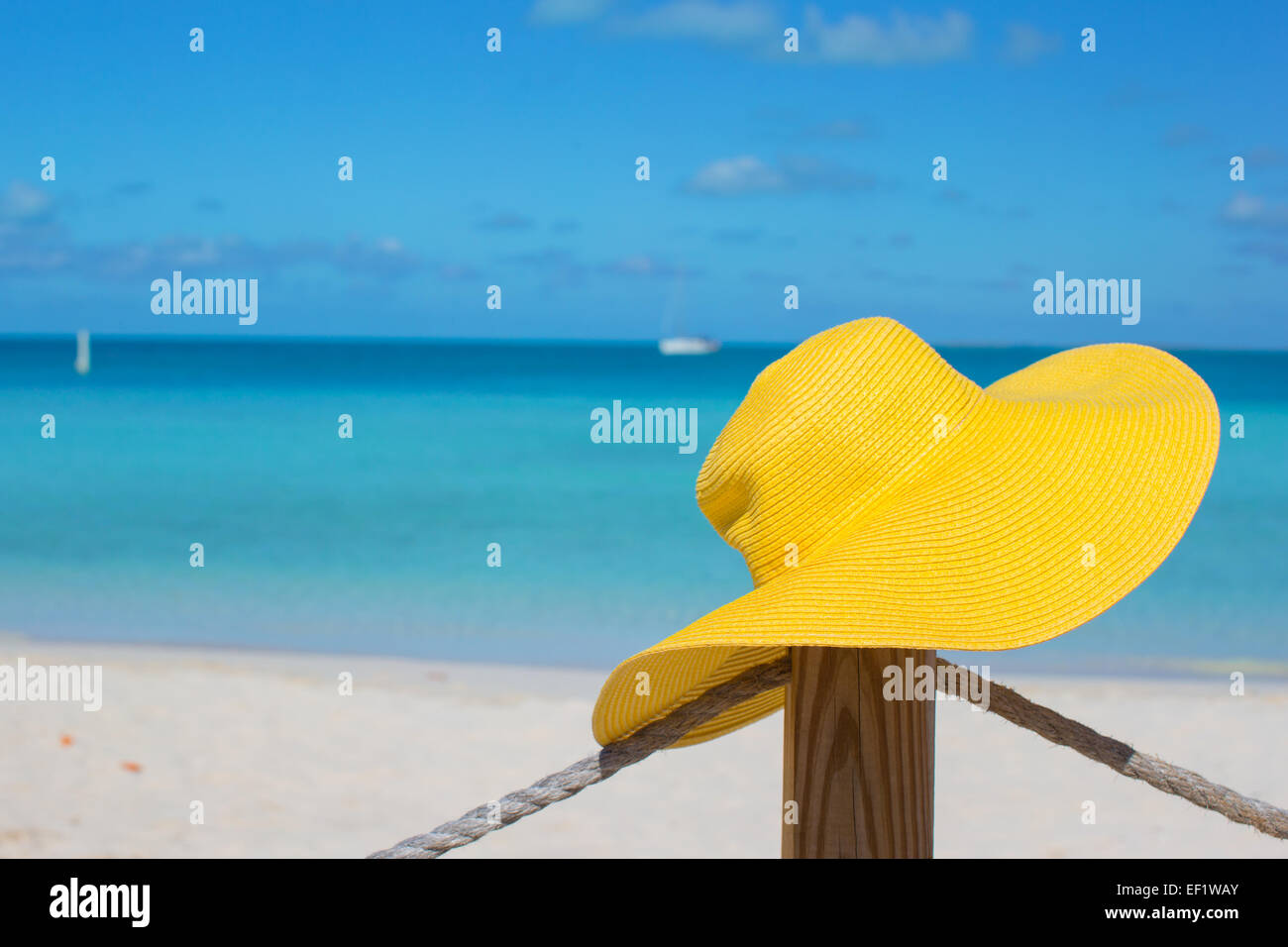 Cappello giallo sulla recinzione al tropical spiaggia bianca Foto Stock