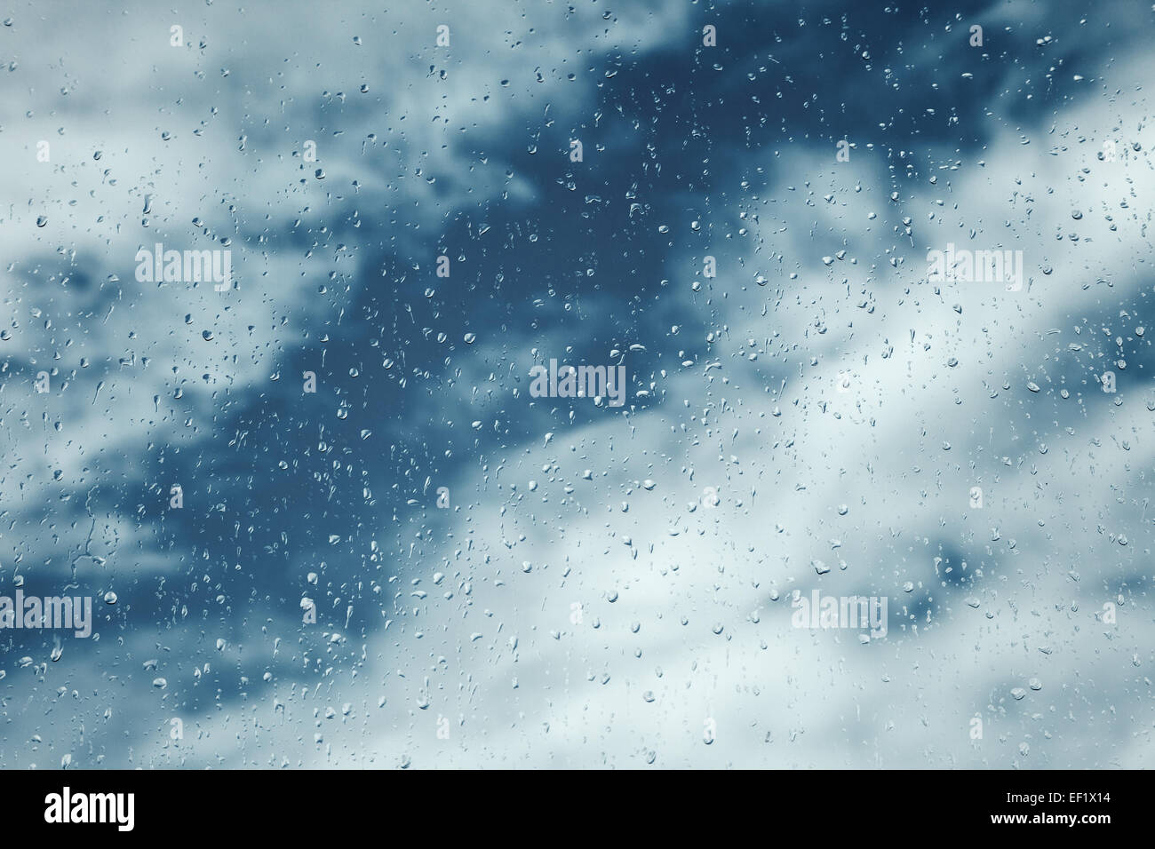 Gocce di pioggia sulla finestra, cielo blu con nuvole sullo sfondo Foto Stock