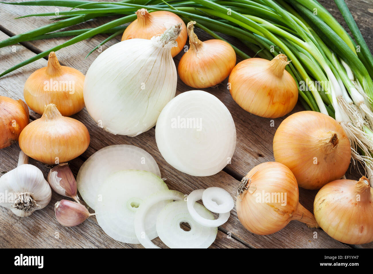Diverse le cipolle e aglio lampadina sul rustico in legno tabella Foto Stock