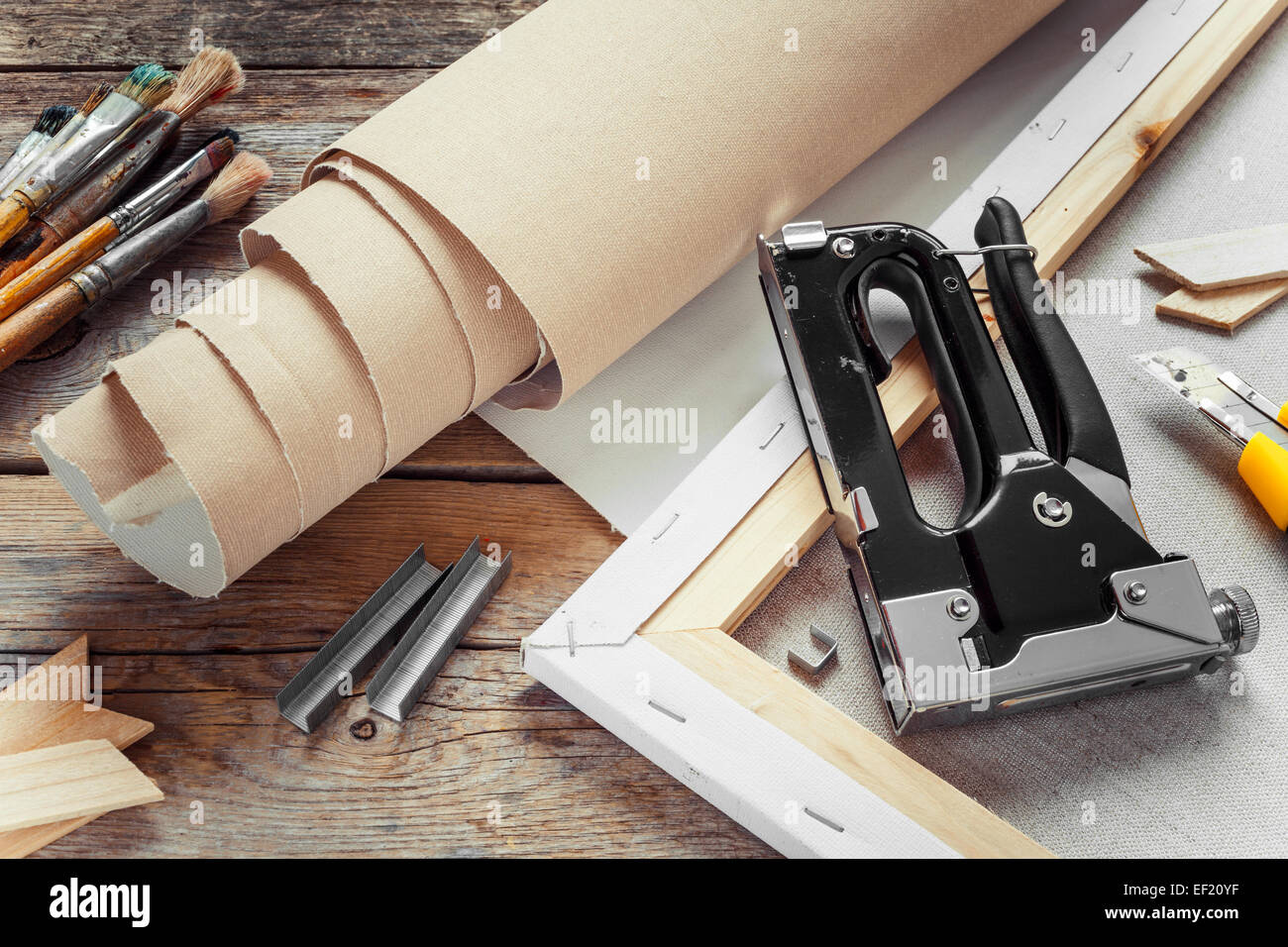 Artist Canvas in rotolo, tela barella, pinzatura pistola e sulla vecchia tabella Foto Stock