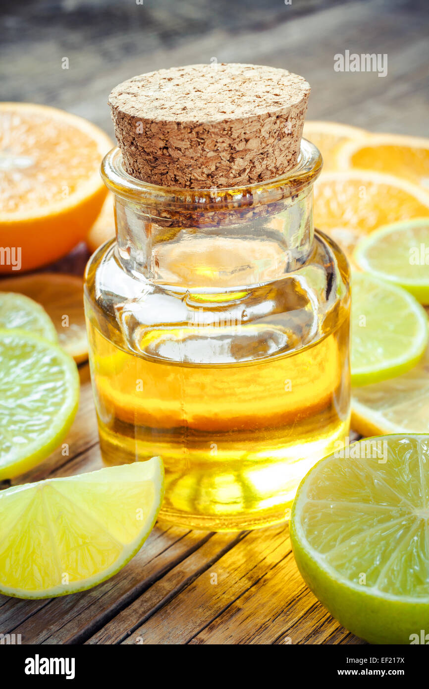 Olio essenziale di agrumi e fette di arancia, limone e frutta di lime Foto Stock