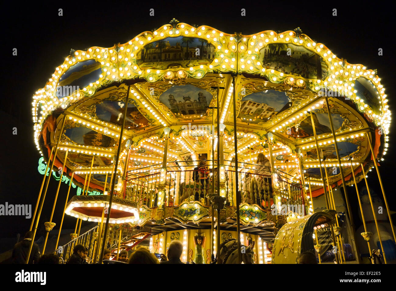 Un francese di stile antico giostra, giostra, merry-go-round, di notte a Malaga, Spagna. Foto Stock