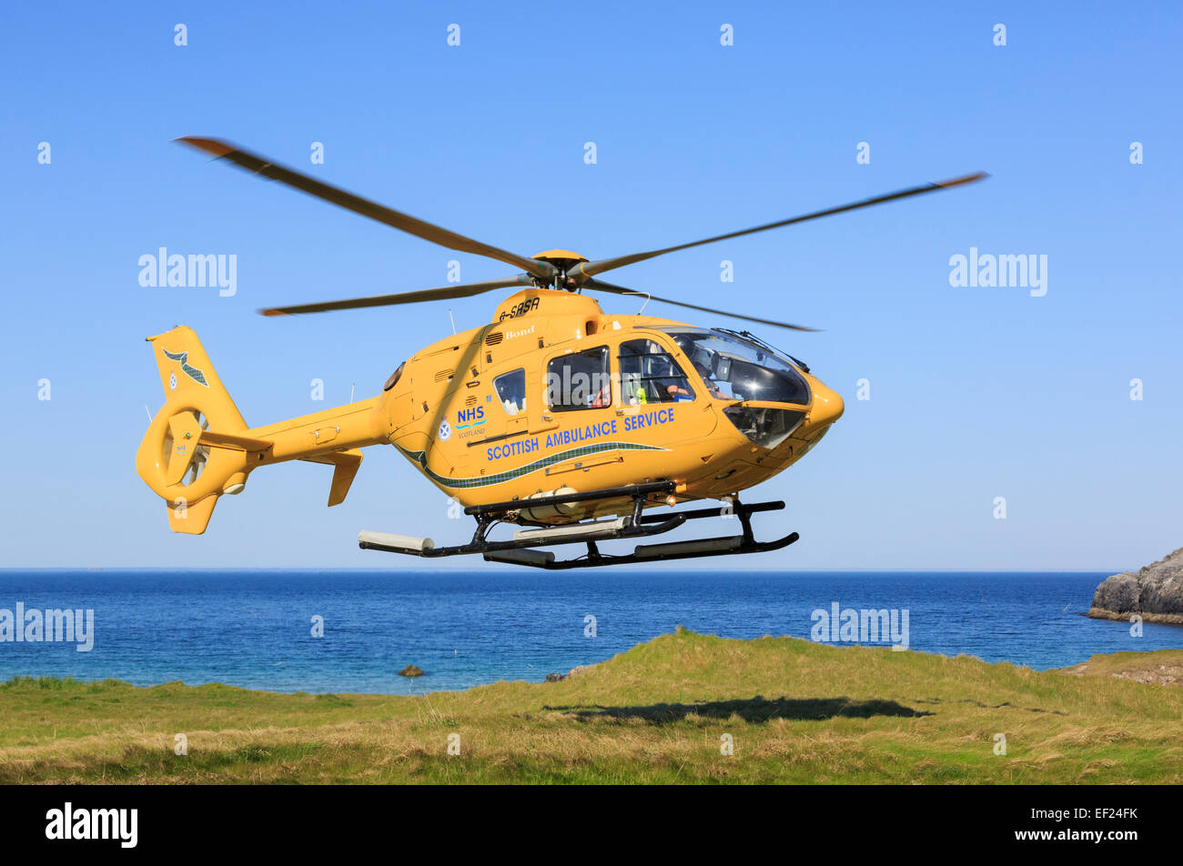 Scottish Air Ambulance Servizio elicottero decollare dopo una missione di soccorso sul telecomando a nord-ovest di Highlands costa. La Scozia, Regno Unito Foto Stock