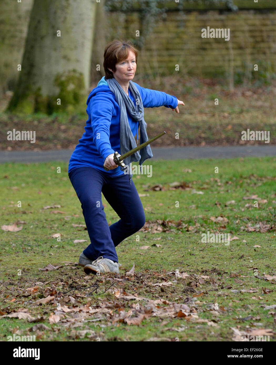 Una donna di praticare il tai chi in un parco Foto Stock