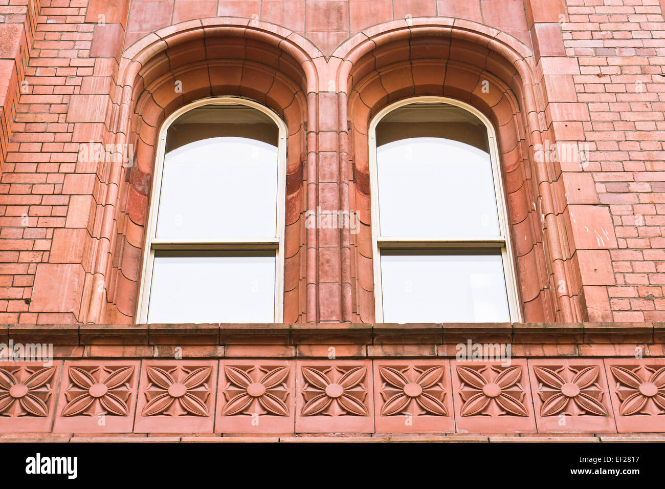 Una coppia di finestre ad arco in un edificio di mattoni rossi a Manchester, Regno Unito Foto Stock