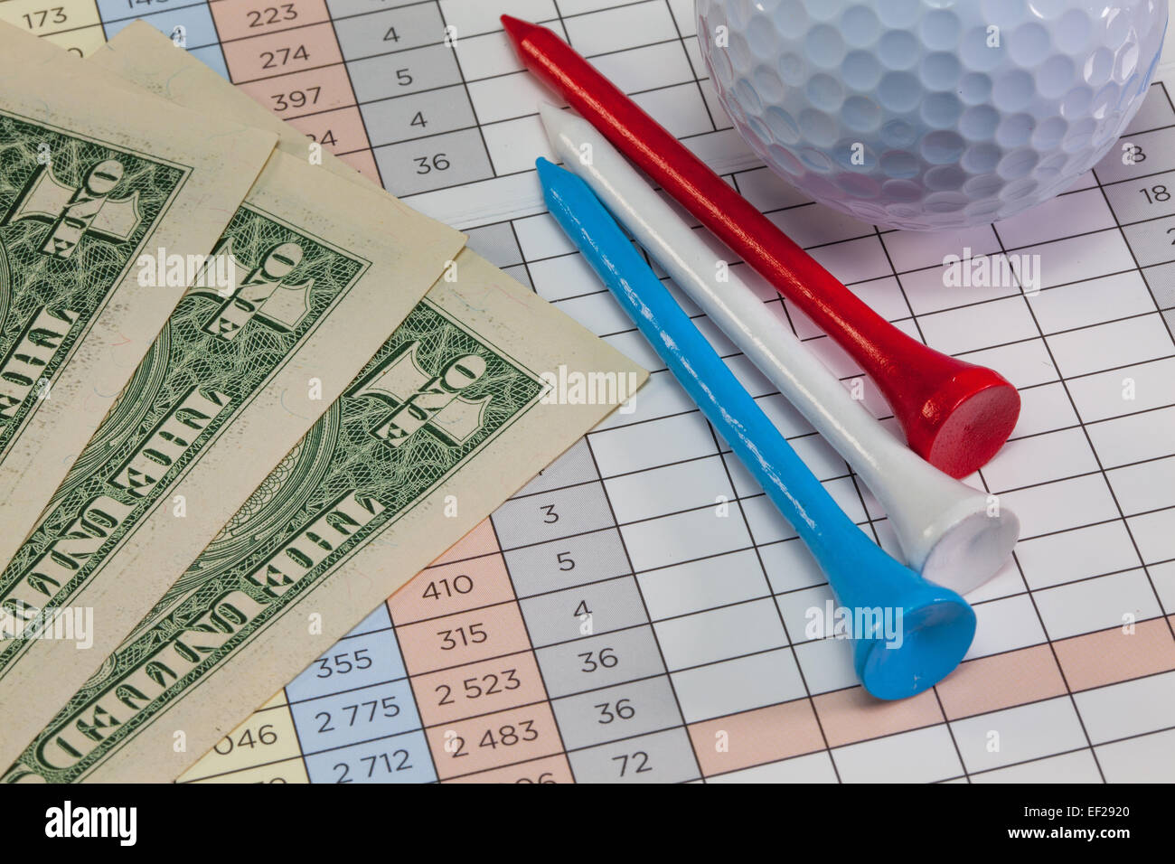 Us dollar banconote e attrezzature da golf giacente su di un campo da golf score card Foto Stock