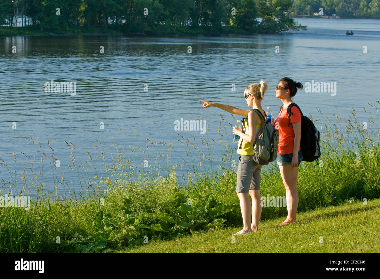 Due amiche in piedi su un litorale rivolta Foto Stock