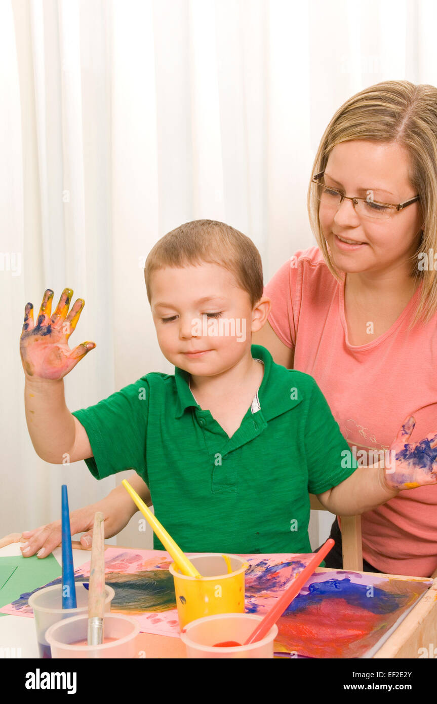 Madre aiutare suo figlio vernice Foto Stock