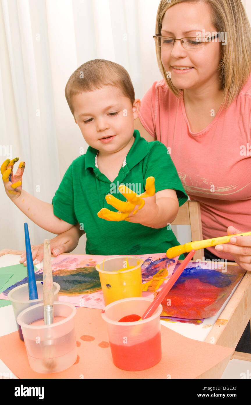 Madre aiutare suo figlio vernice Foto Stock