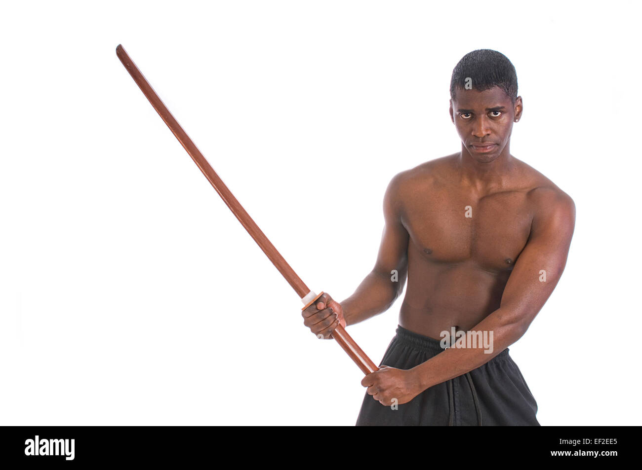 Giovane uomo a praticare il karate con un arma in legno Foto Stock